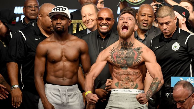 25 августа. Лас-Вегас. Флойд МЕЙВЕЗЕР (слева) и Конор МАКГРЕГОР на официальном взвешивании. Фото AFP 25 августа. Лас-Вегас. Флойд МЕЙВЕЗЕР (слева) и Конор МАКГРЕГОР на официальном взвешивании. Фото AFP