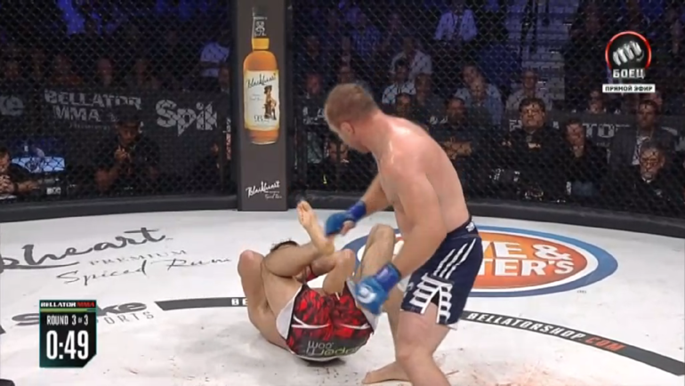 Голландец пытается спастись от мощных ударов Шлеменко и продолжает лежать.