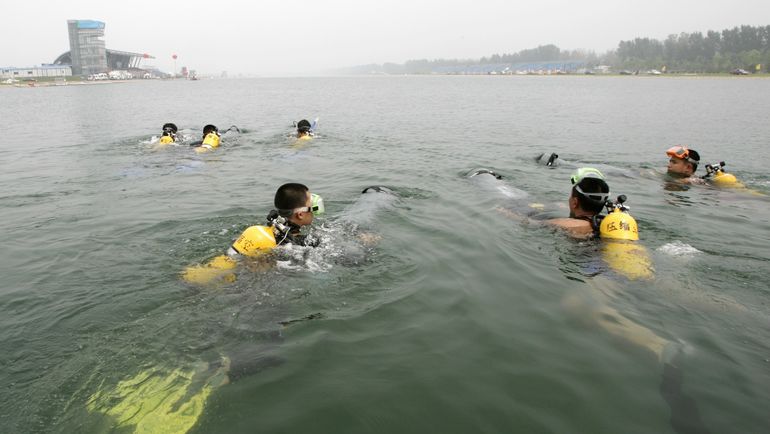 Пекинские дайверы готовятся уйти на дно. Фото REUTERS Пекинские дайверы готовятся уйти на дно. Фото REUTERS