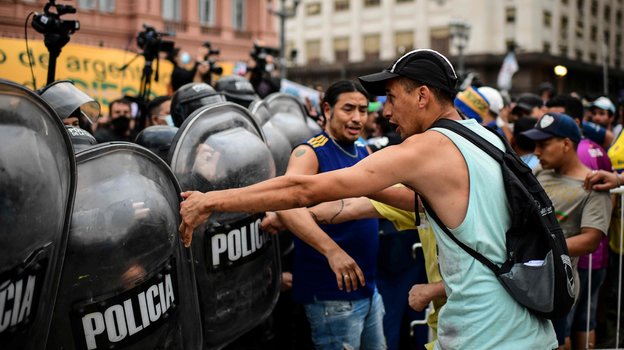 Столкновения фанатов с полицией перед церемонией прощания с Марадоной на входе в президентский дворец «Каса Росада» в Буэнос-Айресе, Аргентина. Фото AFP Столкновения фанатов с полицией перед церемонией прощания с Марадоной на входе в президентский дворец «Каса Росада» в Буэнос-Айресе, Аргентина. Фото AFP