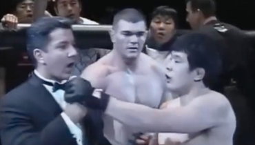 Кадзуши Сакураба пытается отнять микрофон у Брюса Баффера.