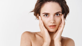 Девушка трогает кожу лица руками