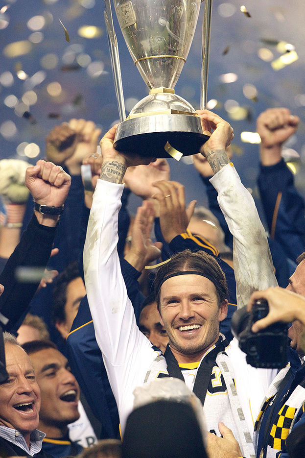 Дэвид Бекхэм с кубком MLS. Футболист Дэвид Бекхэм поднимает над головой кубок MLS.