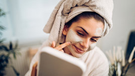 Девушка наносит маску для лица.