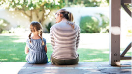 Женщина и девочка сидят на крыльце