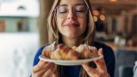 Девушка держит в руках тарелку с выпечкой