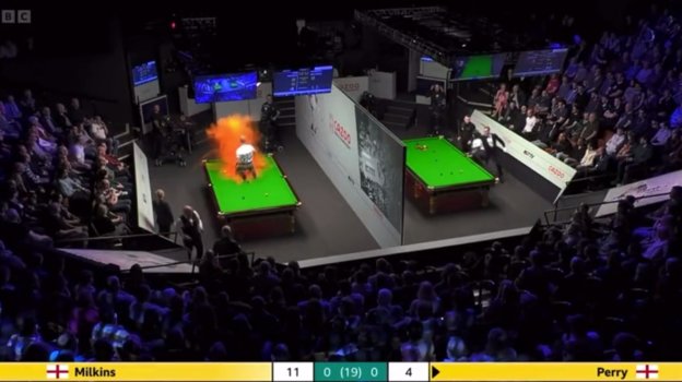 Экоактивист облил стол оранжевой порошковой краской.