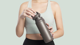 Спортивная девушка с бутылкой в руках