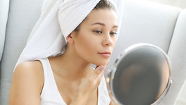 Девушка смотрится в зеркало.