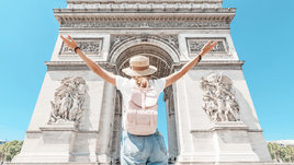 Девушка с рюкзаком на фоне достопримечательности.