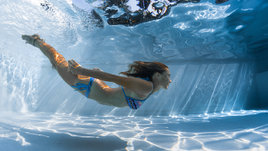 Девушка плавает в бассейне