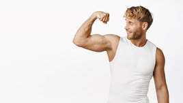 Молодой мужчина показывает большие мускулы