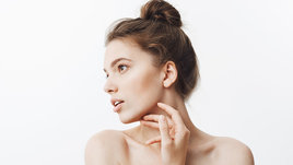 Девушка держится за подбородок.