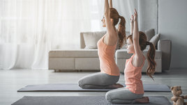 Мама и дочь занимаются йогой дома