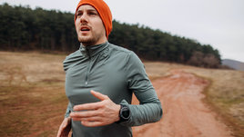 Мужчина дышит с открытым ртом на бегу.