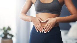 Девушка держится за живот.