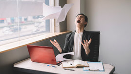 Мужчина азиатской внешности кричит на работе.