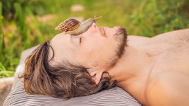 Улитка ползает по лицу мужчины