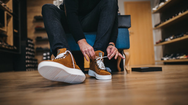 Как выбрать обувь. Парень выбирает обувь в магазине.