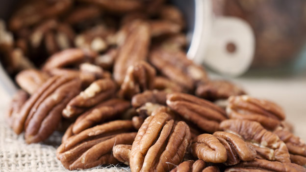 Пекан — отличный источник клетчатки. Пекан рассыпан на столе.