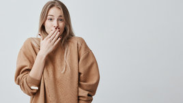 Девушка прикрывает рот рукой.
