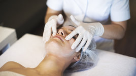 Девушка на приеме у косметолога на чистке лица.