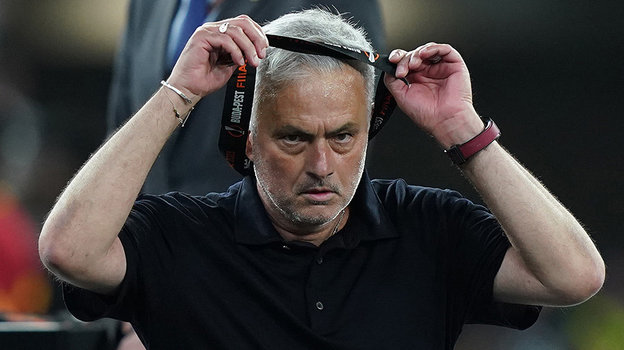 Жозе Моуринью снимает серебряную медаль с шеи.