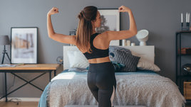 Красивая стройная девушка стоит утром в спальне