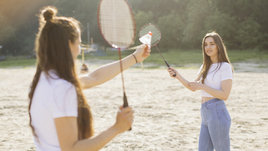 Две девушки играют летом в бадминтон