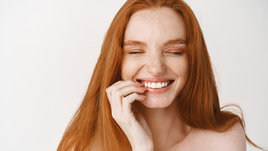 Рыжеволосая девушка улыбается