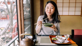 Японская девушка ест азиатскую еду в ресторане