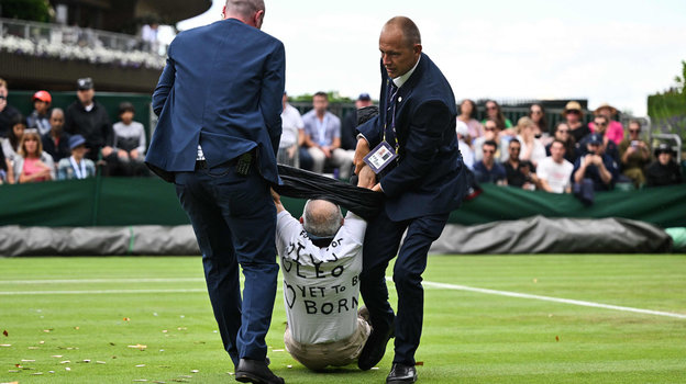 Сотрудники службы безопасности уводят мужчины с корта. Сотрудники службы безопасности уводят мужчины с корта