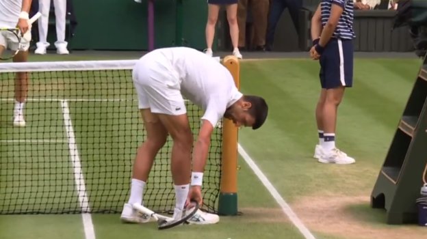 Новак Джокович поднимает сломанную ракетку.