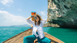 Молодая девушка фотографирует на лодке во время путешествия