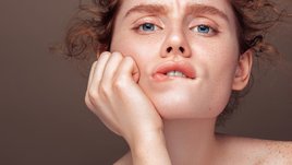 Девушка рассматривает первые морщины вокруг губ