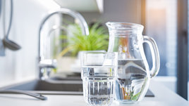 Кувшин с водой и стакан на кухонной столешнице