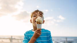 Мальчик ест мороженое