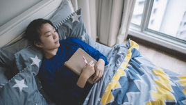 Девушка лежит с блокнотом.