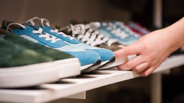 Девушка выбирает кроссовки.