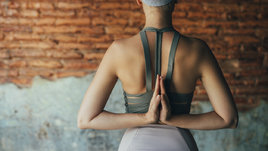 Девушка делает упражнение на растяжку мышц спины.