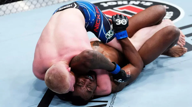 Бо Никаль душит ручным треугольником Джейми Пиккета.