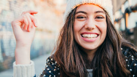 Девушка широко улыбается зимой.