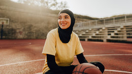 Девушка в хиджабе с баскетбольным мячом