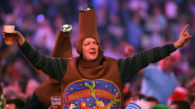 Болельщик с пивом и в костюме пива на турнире по дартсу.