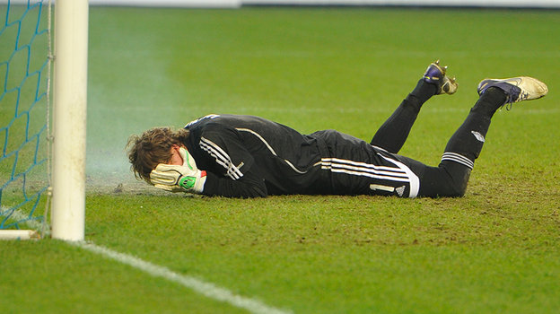 Антон Шунин лежит на газоне после броска петарды.