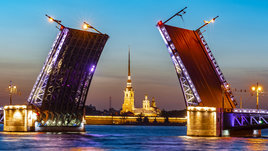 Открытый Дворцовый мост и Петропавловский собор белой ночью