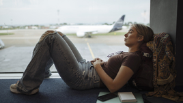 Девушка спит в аэропорту.