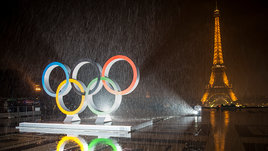 Олимпийские кольца в Париже на фоне Эйфелевой башни.