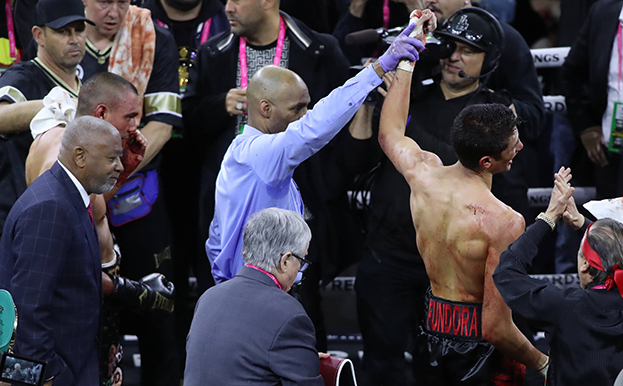 Судья поднимает вверх руку победителя.