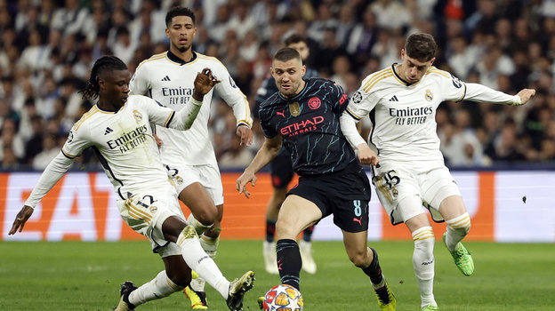 Игроки «Реала» Эдуардо Камавинга и Федерико Вальверде в борьбе с футболистом «Манчестер Сити» Матео Ковачичем.